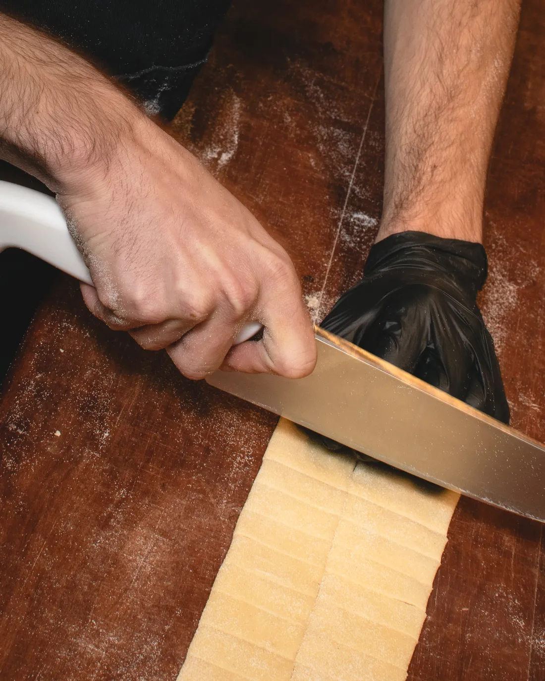 Cortando la masa de pasta a cuchillo sobre la mesada